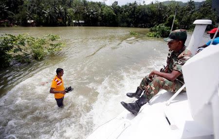 An army officer sits on top of a moving armoured personnel carrier on a flooded road during a rescue mission in Bulathsinhala village, in Kalutara, Sri Lanka May 27, 2017. REUTERS/Dinuka Liyanawatte