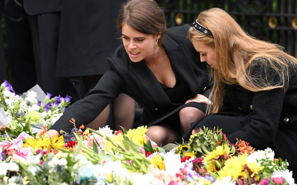 Prinzessin Eugenie und Prinzessin Beatrice sehen sich die Blumen an, die Trauernde am 10. September 2022 vor Schloss Balmoral zurückgelassen haben – Karwai Tang