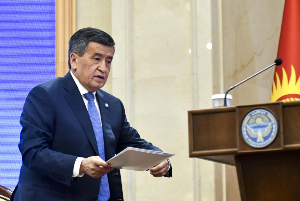 Kyrgyzstan President Sooronbai Jeenbekov walks holding a text of his resignation prior to addressing the Kyrgyzstan Parliament during the transfer of power to Kyrgyz Prime Minister Sadyr Zhaparov in Bishkek, Kyrgyzstan, Friday, Oct. 16, 2020. Kyrgyzstan's embattled president has his resignation, after a disputed parliamentary election in the Central Asian nation. It's the third time in 15 years that a leader of the country has been ousted by a popular uprising. (AP Photo/Vladimir Voronin)