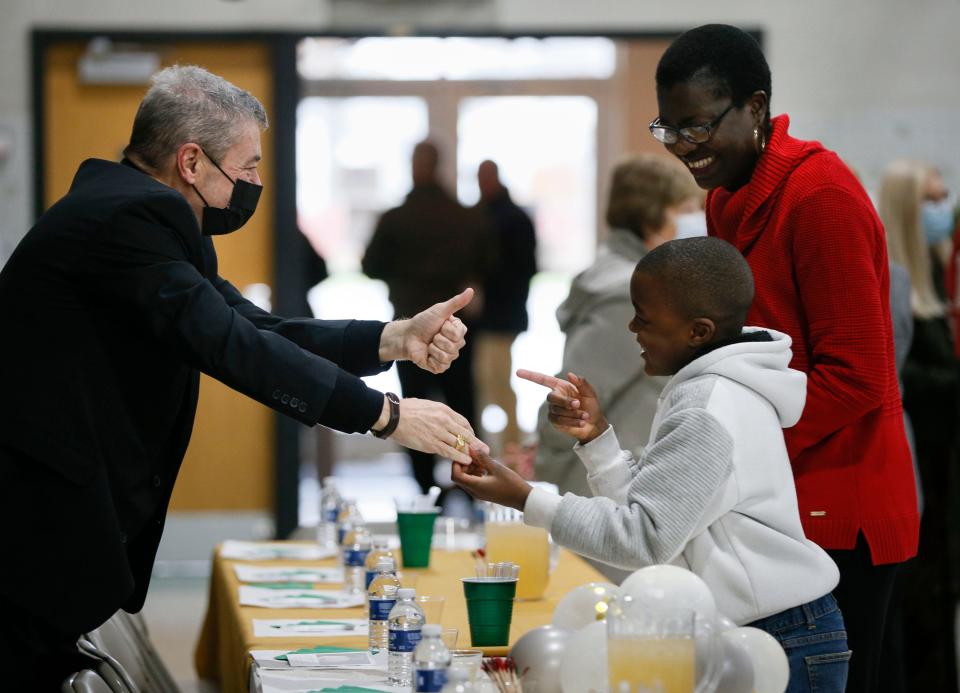 Bishop Robert J Brennan, left, greets Samuel Bissou, 7, left, and his mother Merie after one of Brennan’s last masses in Columbus at Christ the King Catholic Church in Columbus, Ohio, on Sunday, Nov. 21, 2021. “He’s done so much for the church school-wise by investing in their education,” said Merie. 
