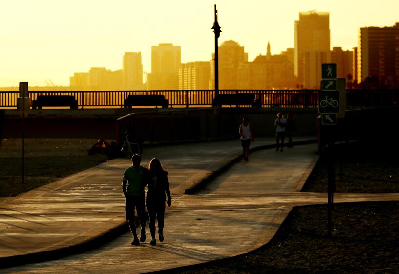 LONG BEACH, CALIF. - SEPT. 22, 2022. Beachgoers walk along the shore near the Belmont Pier in Long Beach on the first day of fall. A warming trend is expected to raise temperatures. throughout Southern California through the weekend. (Luis Sinco / Los Angeles Times)