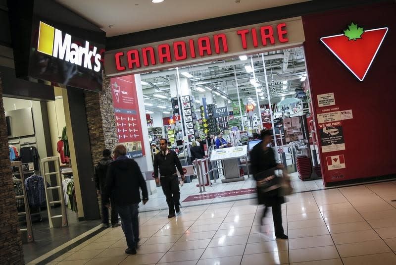 People walk out of a Canadian Tire Store that is located by a Mark’s clothing store, which is owned by Canadian Tire Corporation in Toronto, May 8, 2014. (Reuters)