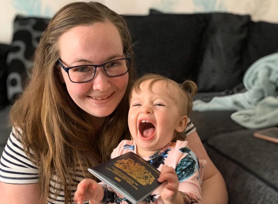 Danielle Hugman, 25, with her one-year-old Willow-Rose, and her new blue passport. (SWNS)