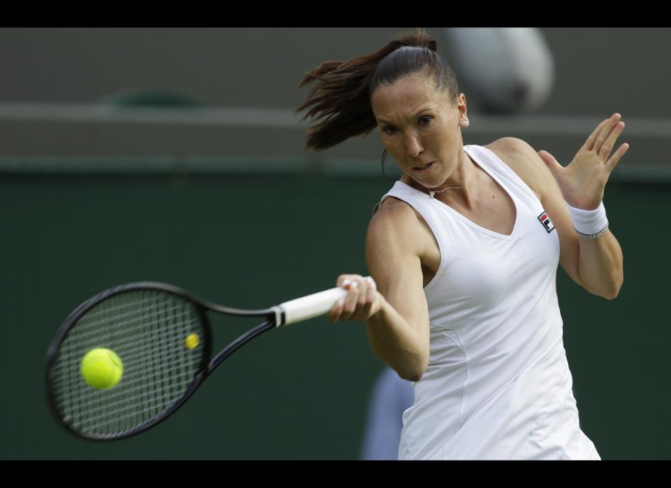 Jelena Jankovic of Serbia returns a shot to Kim Clijsters of Belgium during a first round women's singles match at the All England Lawn Tennis Championships at Wimbledon, England, Monday, June 25, 2012. 