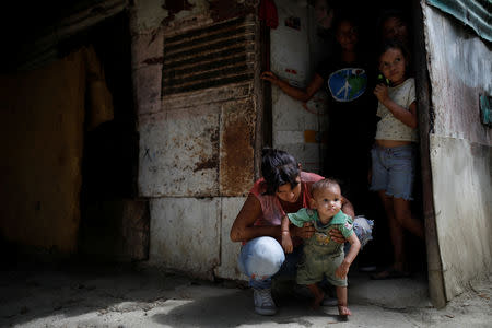 Maria Guitia holds her one-year old son Yeibe Medina, outside their home near San Francisco de Yare, Venezuela, February 18, 2019. REUTERS/Carlos Garcia Rawlins