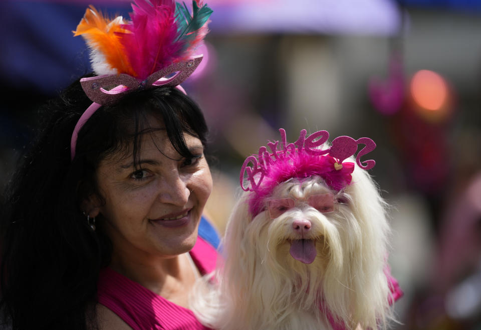 A woman poses for a photo with her pet during the "Blocao" dog carnival parade, in Rio de Janeiro, Brazil, Saturday, Feb. 18, 2023. (AP Photo/Silvia Izquierdo)