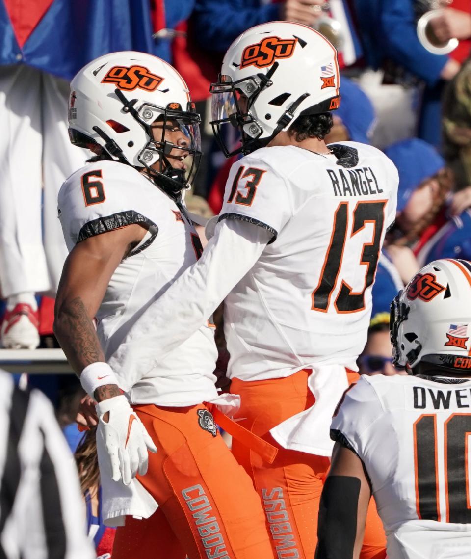 Oklahoma State Cowboys wide receiver Stephon Johnson Jr. (6) celibrates with quarterback Garret Rangel (13) after scoring against the Kansas Jayhawks during the first half of the game at David Booth Kansas Memorial Stadium.