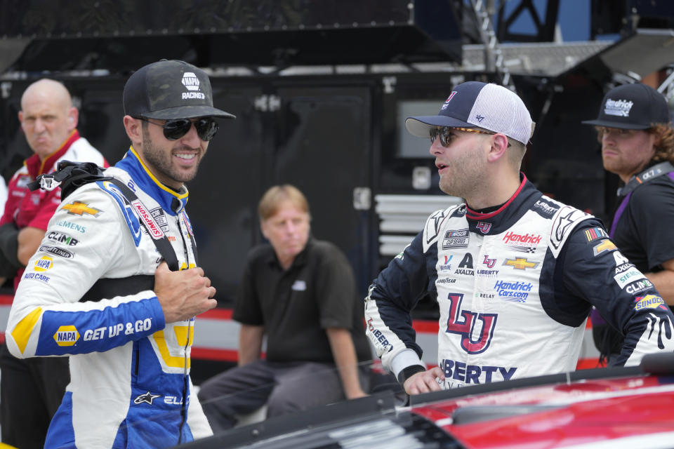 Chase Elliott, left, and William Byron talk during qualifications for a NASCAR Cup Series auto race at Michigan International Speedway in Brooklyn, Mich., Saturday, Aug. 5, 2023. (AP Photo/Paul Sancya)