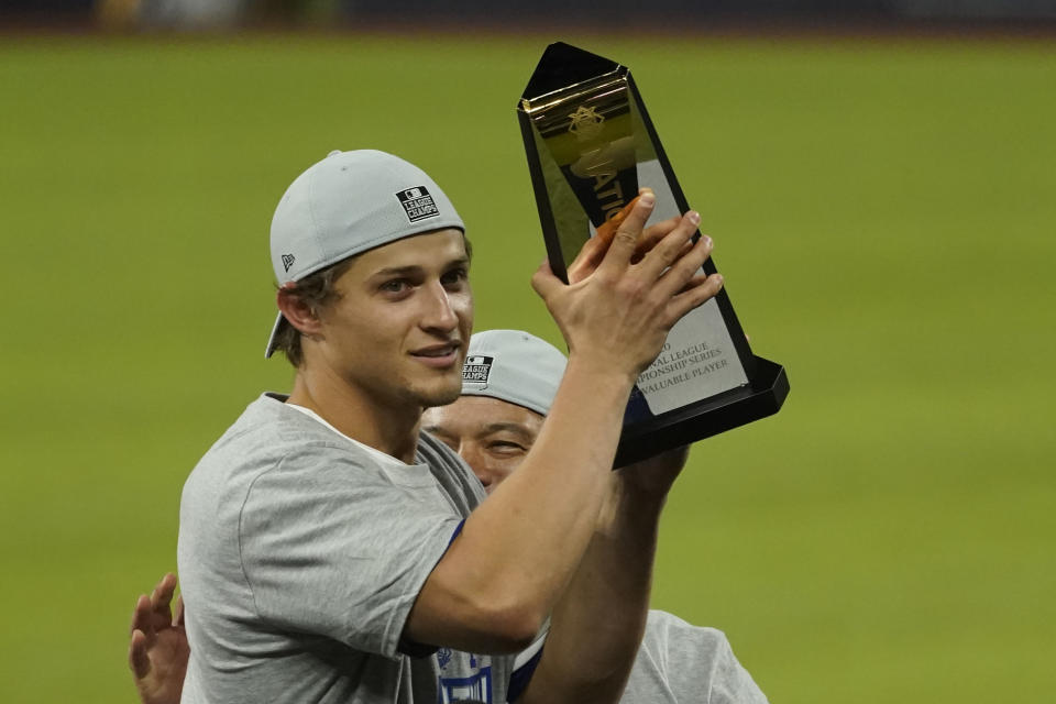 Los Angeles Dodgers shortstop Corey Seager celebrates with the MVP trophy after winning Game 7 of a baseball National League Championship Series against the Atlanta Braves Sunday, Oct. 18, 2020, in Arlington, Texas. (AP Photo/Eric Gay)