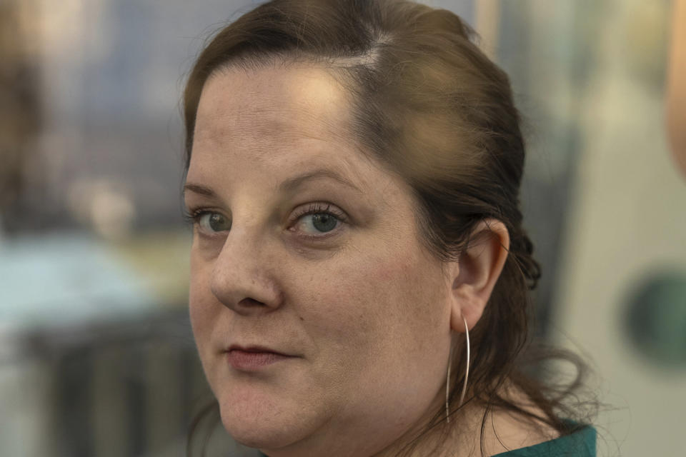 Emily Hollenbeck, a deep brain stimulation therapy patient being treated for depression, stands for a portrait at the American Museum of Natural History's Rose Center in New York on Jan. 12, 2024. “When I was depressed, I couldn’t listen to music. It sounded and felt like I was listening to radio static,” she says. “Then on a sunny day in the summer, I was walking down the street listening to a song. I just felt this buoyancy, this, ‘Oh, I want to walk more, I want to go and do things!’ And I realized I’m getting better.” She only wishes the therapy had been there for her parents. (AP Photo/Mary Conlon)