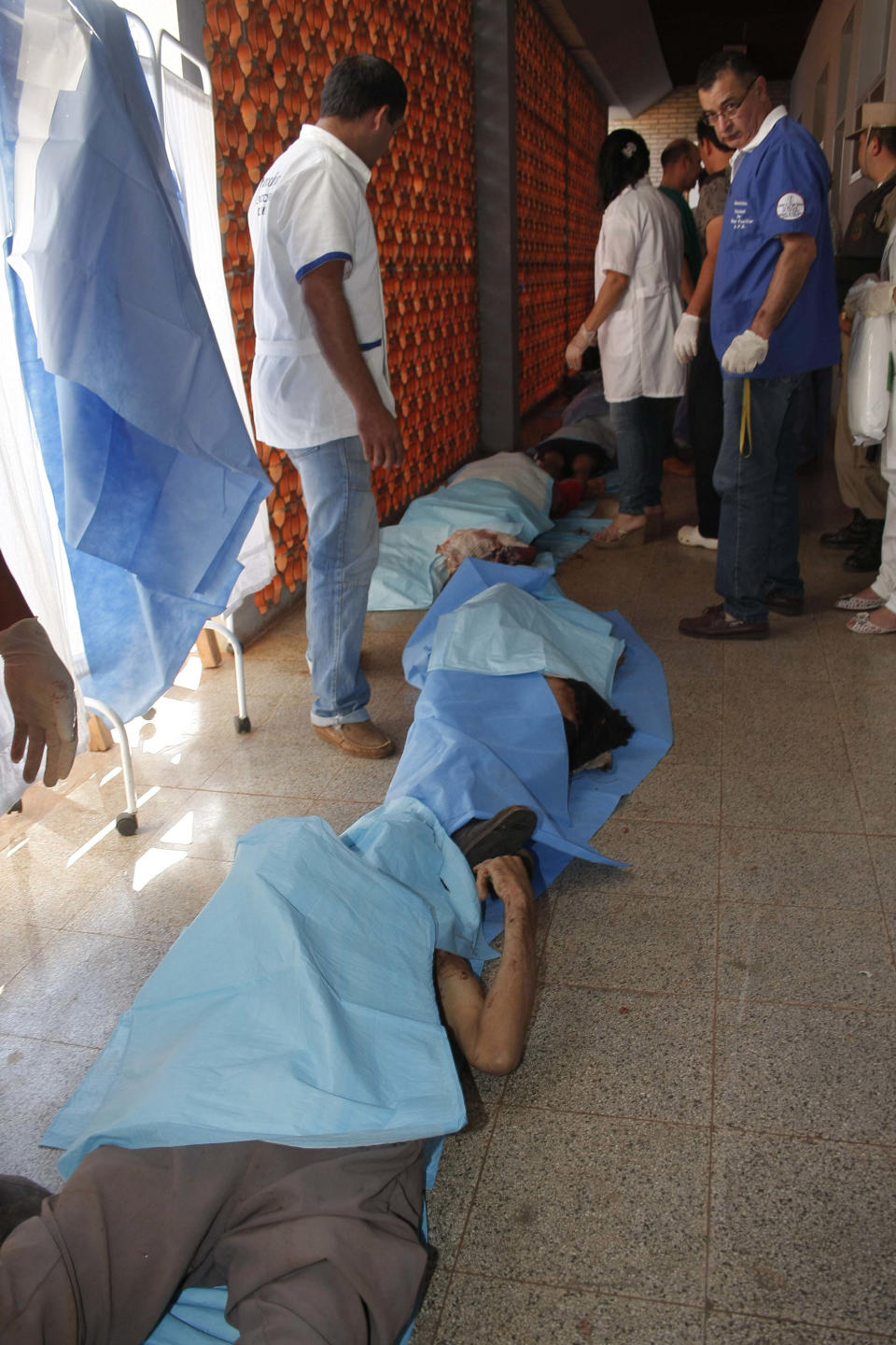 The bodies of farmers killed by police during a land eviction, lie covered on a hospital floor in Curuguaty, Paraguay, Friday, June 15, 2012. Paraguay deployed its army on Friday to resolve the violent land dispute in Curuguaty, a remote northern forest reserve, where 17 people have been killed in gun battles between police and landless farmers when police were trying to evict about 150 farmers from the reserve, which is part of a huge estate owned by a Colorado Party politician opposed to leftist President Fernando Lugo. (AP Photo)