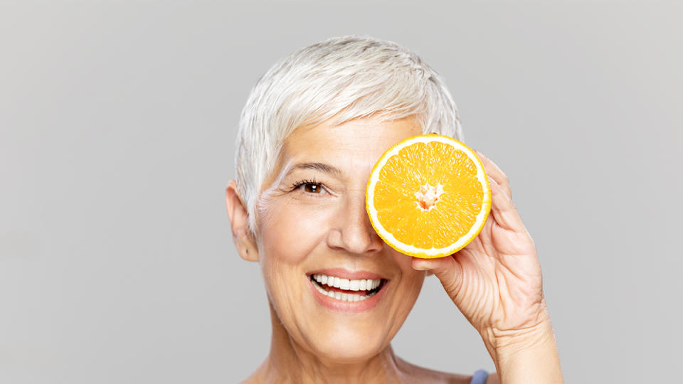 woman holding an orange up to her face; uses for orange peels