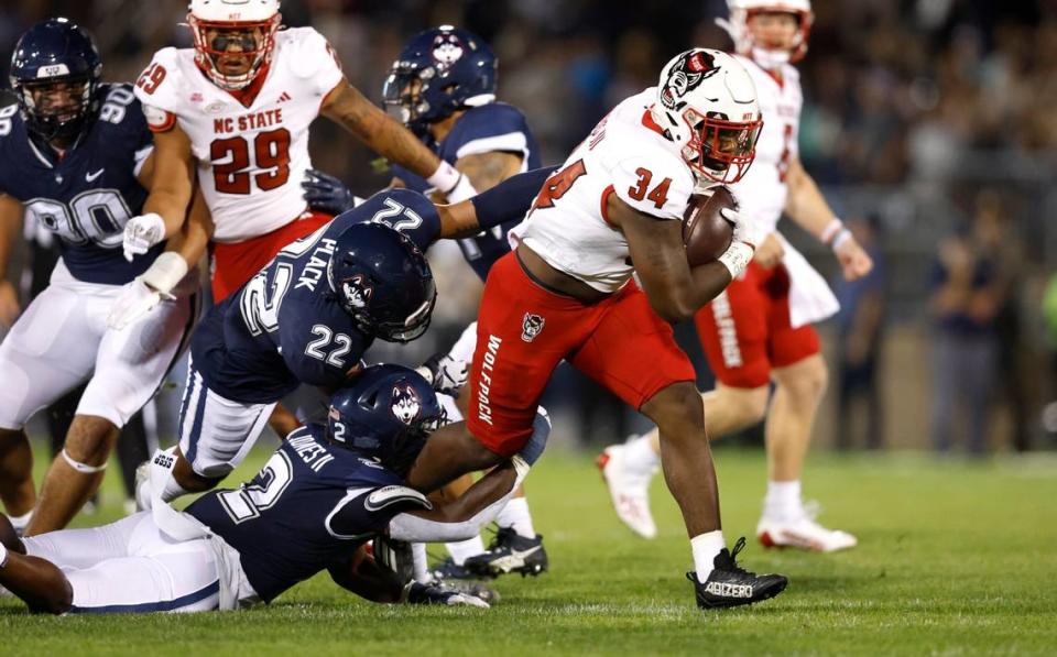 N.C. State running back Delbert Mimms III (34) breaks free from Connecticut defensive back Durante Jones (2) during the first half of N.C. State’s game against UConn at Rentschler Field in East Hartford, Conn. Thursday, August 31, 2023.
