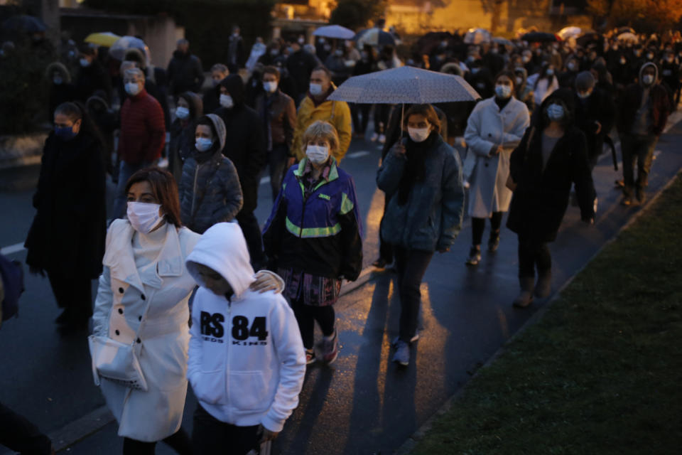 People attend a memorial march in homage to the history teacher who was beheaded last week, Tuesday, Oct.20, 2020 in Conflans-Sainte-Honorine, northwest of Paris. Samuel Paty was beheaded on Friday by an 18-year-old Moscow-born Chechen refugee, who was later shot dead by police. Police officials said Paty had discussed caricatures of Islam's Prophet Muhammad with his class, leading to threats. (AP Photo/Lewis Joly)