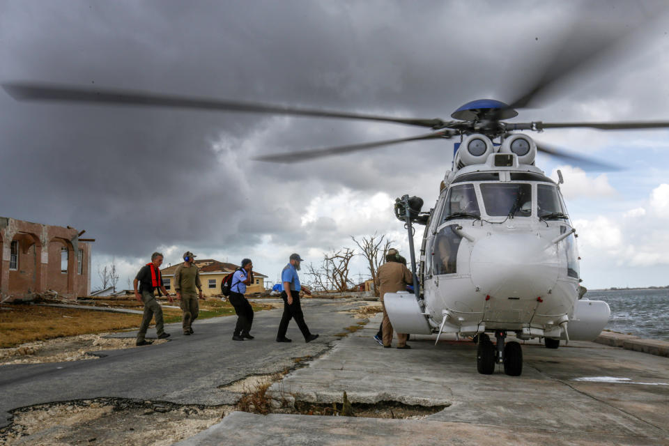 In this Sept. 16, 2019 photo, a team sent by the Bahamian government to check on the conditions of clinics, leaves from inspecting a destroyed clinic in McLean's Town Cay, Grand Bahama Island, Bahamas. Bahamians are still struggling weeks after Hurricane Dorian destroyed much of the infrastructure, including more than 13,000 homes. (Chris Day/University of Florida via AP)