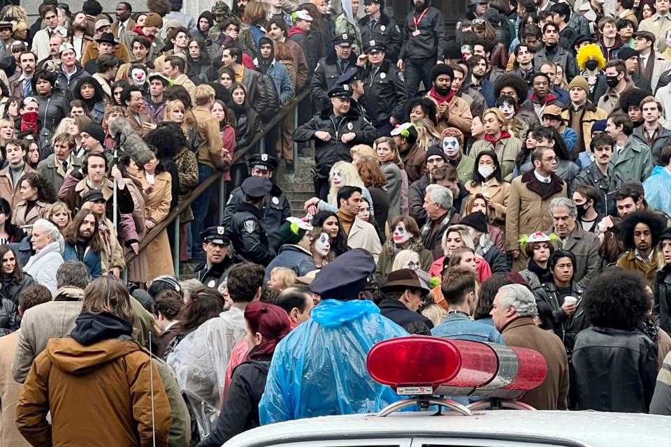 Throngs of actors portraying protesters, some in make-up, gather for the filming of a scene in the "Joker" movie sequel in New York, Saturday, March 25, 2023. (AP Photo/Bobby Caina Calvan)