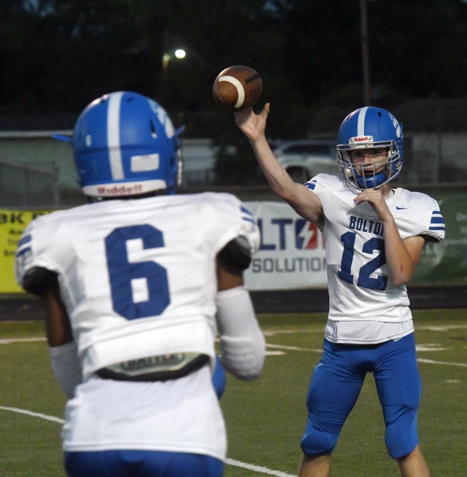 Bolton quarterback Connor Mclain (12) throws to Kesean Gilliam (6) in a game against Tioga. McLain is a punter and kicker who stepped into the role of quarterback this season.