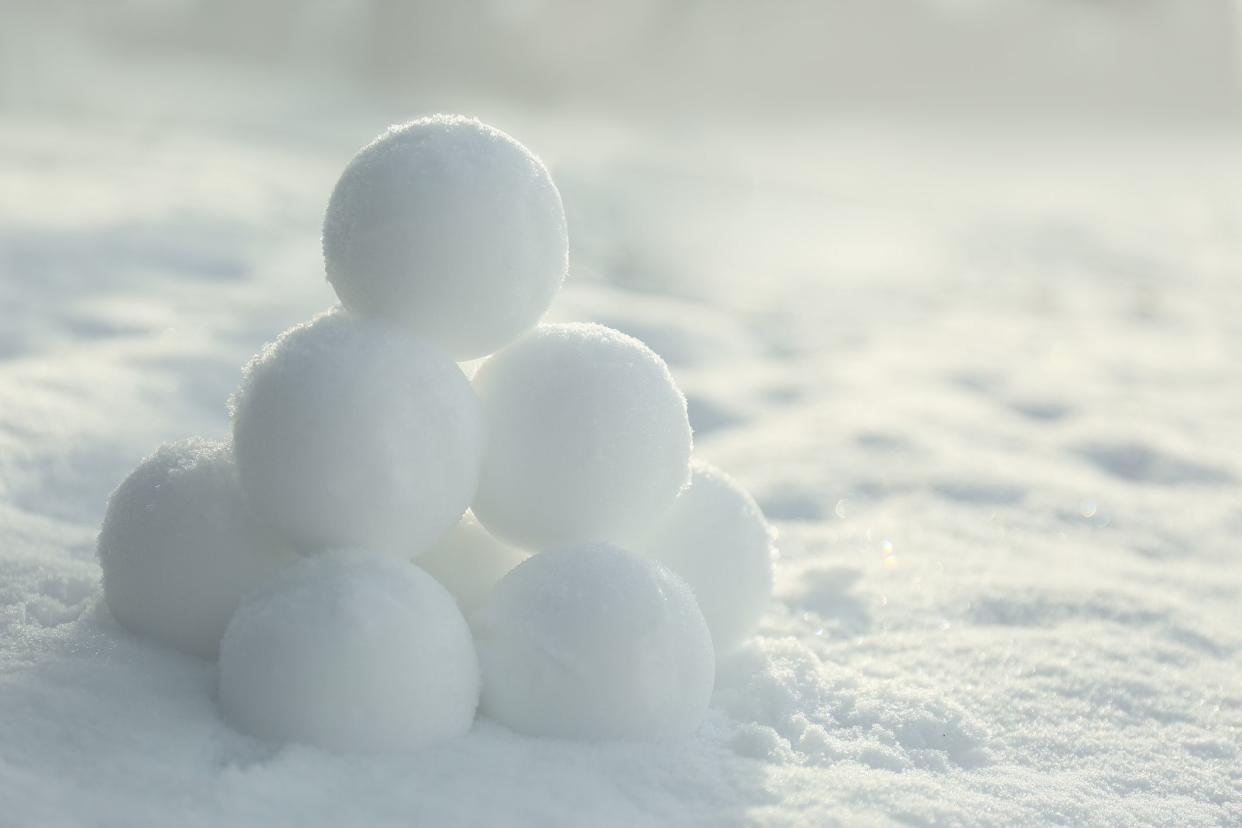 Pyramid of perfect snowballs on snow outdoors, closeup