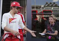 Ferrari Formula One driver Fernando Alonso (L) of Spain reaches out to sign an autograph before the start of the qualifying session of the Italian F1 Grand Prix at the Monza circuit September 7, 2013. REUTERS/Enrico Schiavi (ITALY - Tags: SPORT MOTORSPORT F1)