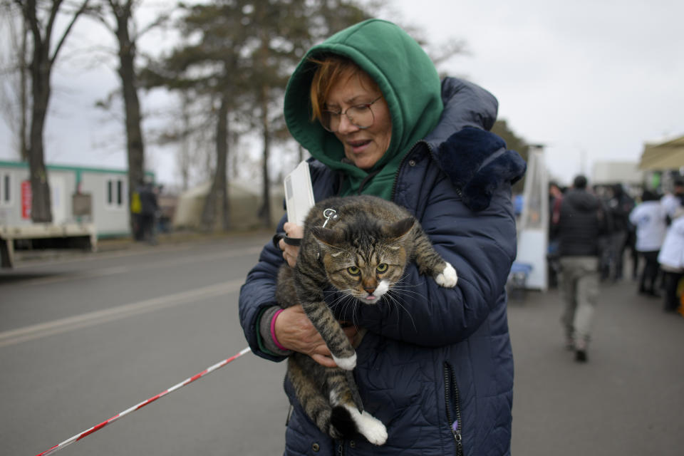 A refugee fleeing the conflict from neighbouring Ukraine holds her pet cat at the Romanian-Ukrainian border, in Siret, Romania, Saturday, March 5, 2022. (AP Photo/Andreea Alexandru)