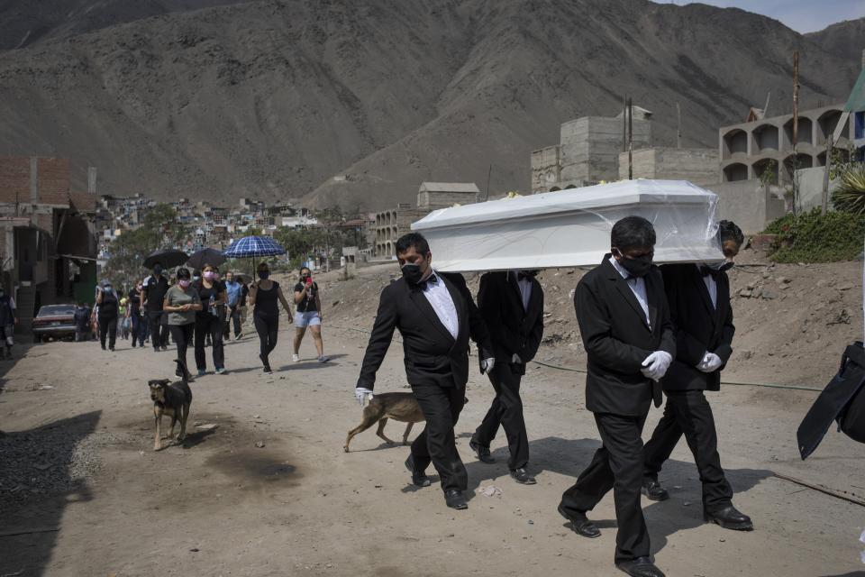 Funeral home workers carry the coffin of Pedro Miguel Infante Vilchez, 80, who died from COVID-19, to the "Martires 19 de Julio" cemetery in Comas, on the outskirts of Lima, Peru, Thursday, Jan. 21, 2021. (AP Photo/Rodrigo Abd)