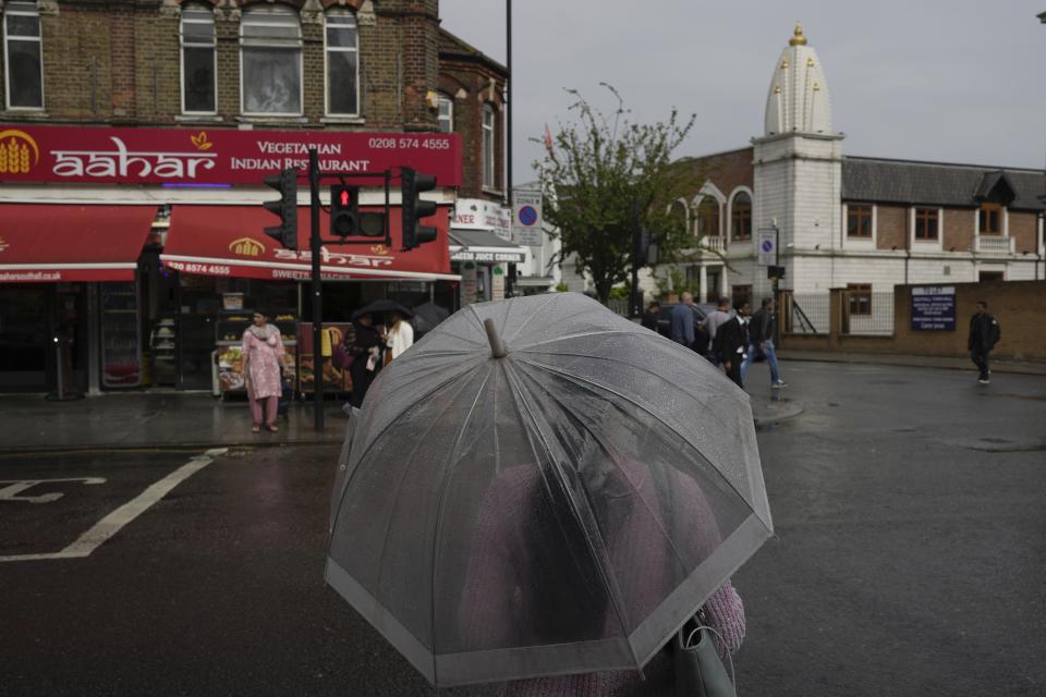 A woman walks near the Hindu temple in the district of Southall in London, Tuesday, Sept. 13, 2022. In a church in a West London district known locally as Little India, a book of condolence for Queen Elizabeth II lies open. Five days after the monarch’s passing, few have signed their names. The congregation of 300 is made up largely of the South Asian diaspora, like the majority of the estimated 70,000 people living in the district of Southall, a community tucked away in London's outer reaches of London and built on waves of migration that span 100 years. (AP Photo/Kin Cheung)