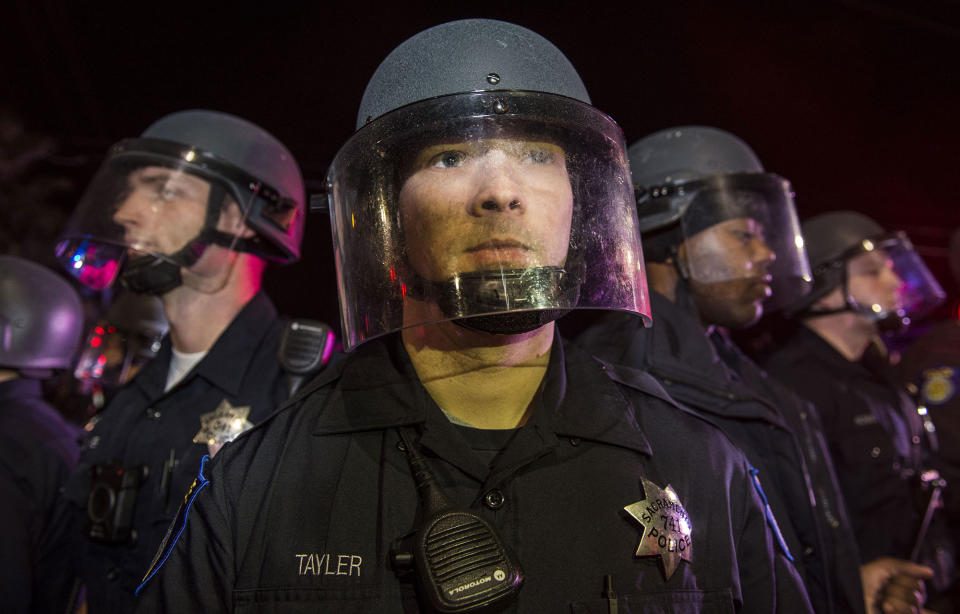 <p>Sacramento police officers stand their ground after one of the department’s patrol cars was vandalized by participants of a candlelight vigil in honor of Stephon Clark in South Sacramento on Friday, March 23, 2018. (Photo: Hector Amezcua/Sacramento Bee via ZUMA Wire) </p>