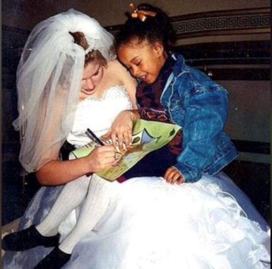 Five-year-old Imari Stout sits on Cinderella's lap and gets her program autographed.