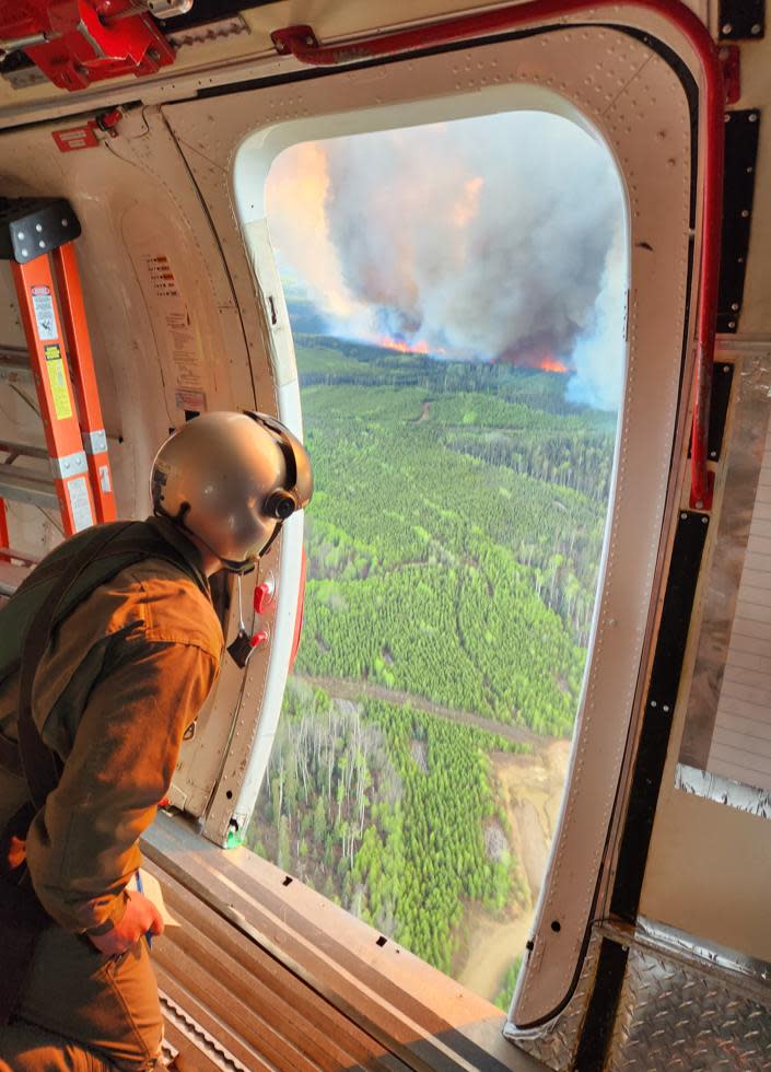 A firefighter observes the Donnie Creek wildfire from a plane in an undated photograph. The largest wildfire ever recorded in B.C. has been burning since May 12 and was estimated to be 5,831 square kilometres in size on Aug. 28. (B.C. Wildfire Service - image credit)