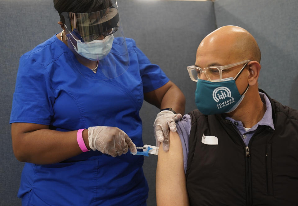 Licensed vocational nurse LeShay Brown inoculates California Health and Human Services Secretary Dr. Mark Ghaly at the Baldwin Hills Crenshaw Plaza in Los Angeles, Thursday, March 11, 2021. The California Department of Public Health is highlighting the new the one-dose Johnson & Johnson COVID-19 vaccine. (AP Photo/Damian Dovarganes)