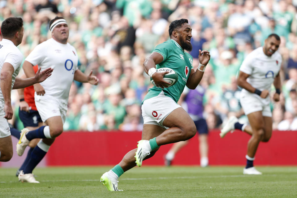 Ireland's Bundee Aki, centre, breaks away from England's players to score a try during the international rugby union match between Ireland and England, at Aviva Stadium, Dublin, Ireland, Saturday, Aug. 19, 2023. (AP Photo/Peter Morrison)