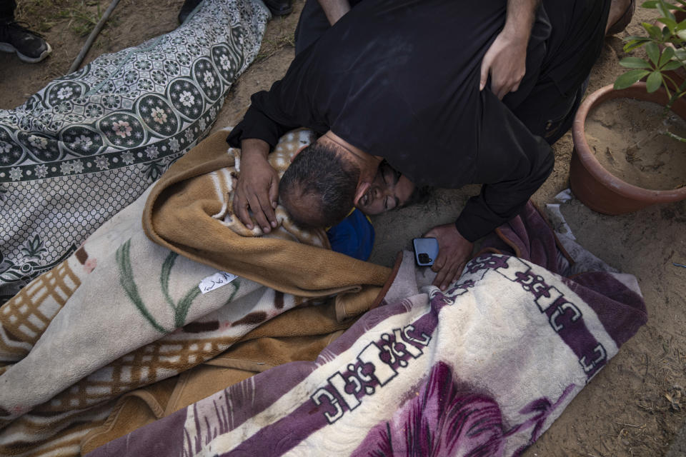 Palestinos llorando a parientes muertos en un bombardeo israelí sobre la Franja de Gaza, en un morgue de Khan Younis, el martes 17 de octubre de 2023. (AP Foto/Fatima Shbair)