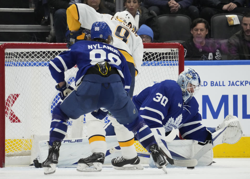 Nashville Predators left wing Filip Forsberg (9) scores on Toronto Maple Leafs goaltender Matt Murray (30) as Maple Leafs right wing William Nylander (88) defends during the second period of an NHL hockey game, Wednesday, Jan. 11, 2023 in Toronto. (Frank Gunn/The Canadian Press via AP)