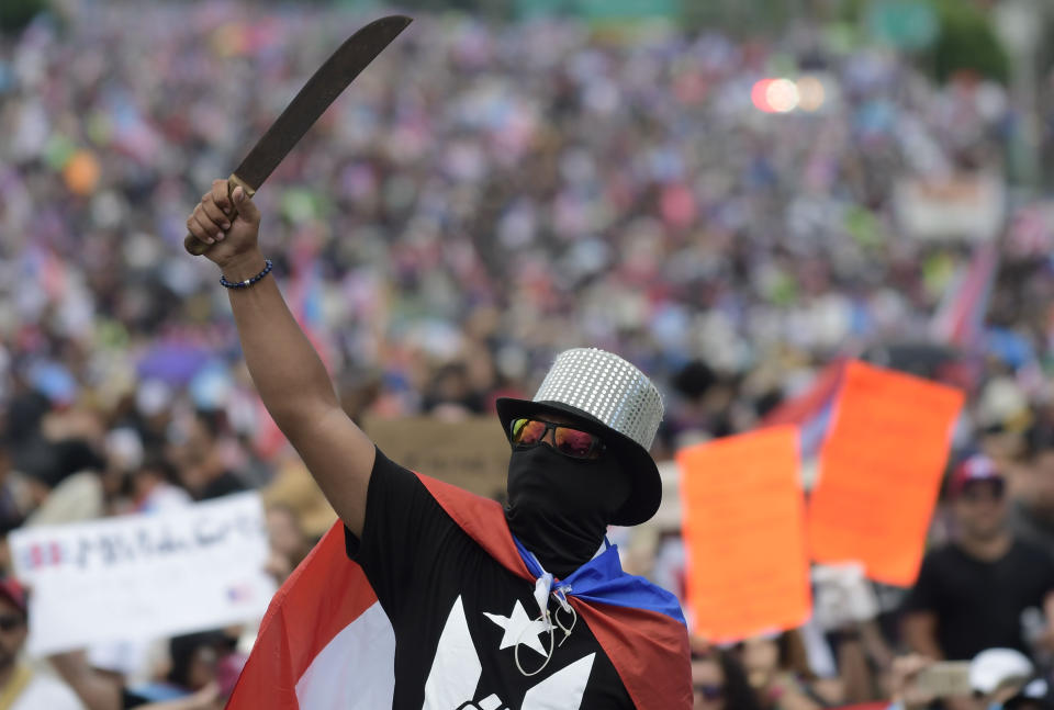 A demonstrator brandishes a machete during a march on Las Americas highway to demand the resignation of governor Ricardo Rossello, in San Juan, Puerto Rico, Monday, July 22, 2019. Protesters are demanding Rossello step down for his involvement in a private chat in which he used profanities to describe an ex-New York City councilwoman and a federal control board overseeing the island's finance. (AP Photo/Carlos Giusti)