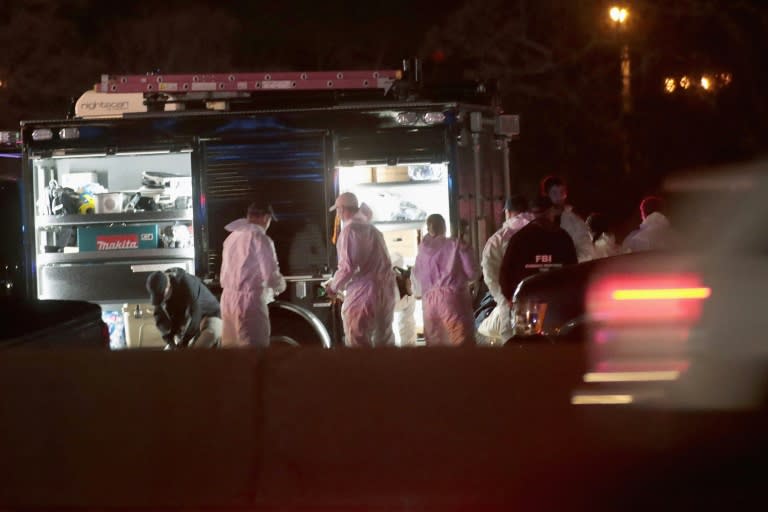 Law enforcement officials put on protective gear as they investigate the place where the suspected package bomber blew himself up in suburban Austin