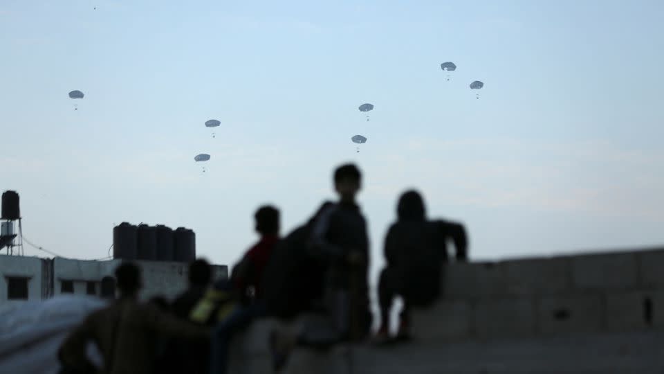 Palestinians watch as the US military carries out its first aid drop over Gaza City, in northern Gaza, on March 2. Human rights groups say the drops are a degrading way of getting aid to Gazans. - Kosay Al Nemer/Reuters