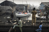 <p>Lagos waterfronts under threat: A boat with expats from Lagos Marina is steered through the canals of Makoko community — an ancient fishing village that has grown into an enormous informal settlement — on the shores of Lagos Lagoon, Lagos, Nigeria, Feb. 24, 2017.<br>Makoko has a population of around 150,000 people, many of whose families have been there for generations. But Lagos is growing rapidly, and ground to build on is in high demand. Prime real estate along the lagoon waterfront is scarce, and there are moves to demolish communities such as Makoko and build apartment blocks: accommodation for the wealthy. Because the government considers the communities to be informal settlements, people may be evicted without provision of more housing. Displacement from the waterfront also deprives them of their livelihoods. The government denies that the settlements have been inhabited for generations and has given various reasons for evictions, including saying that the communities are hideouts for criminals. Court rulings against the government in 2017 declared the evictions unconstitutional and that residents should be compensated and rehoused, but the issue remains unresolved. (Photo: Jesco Denzel) </p>