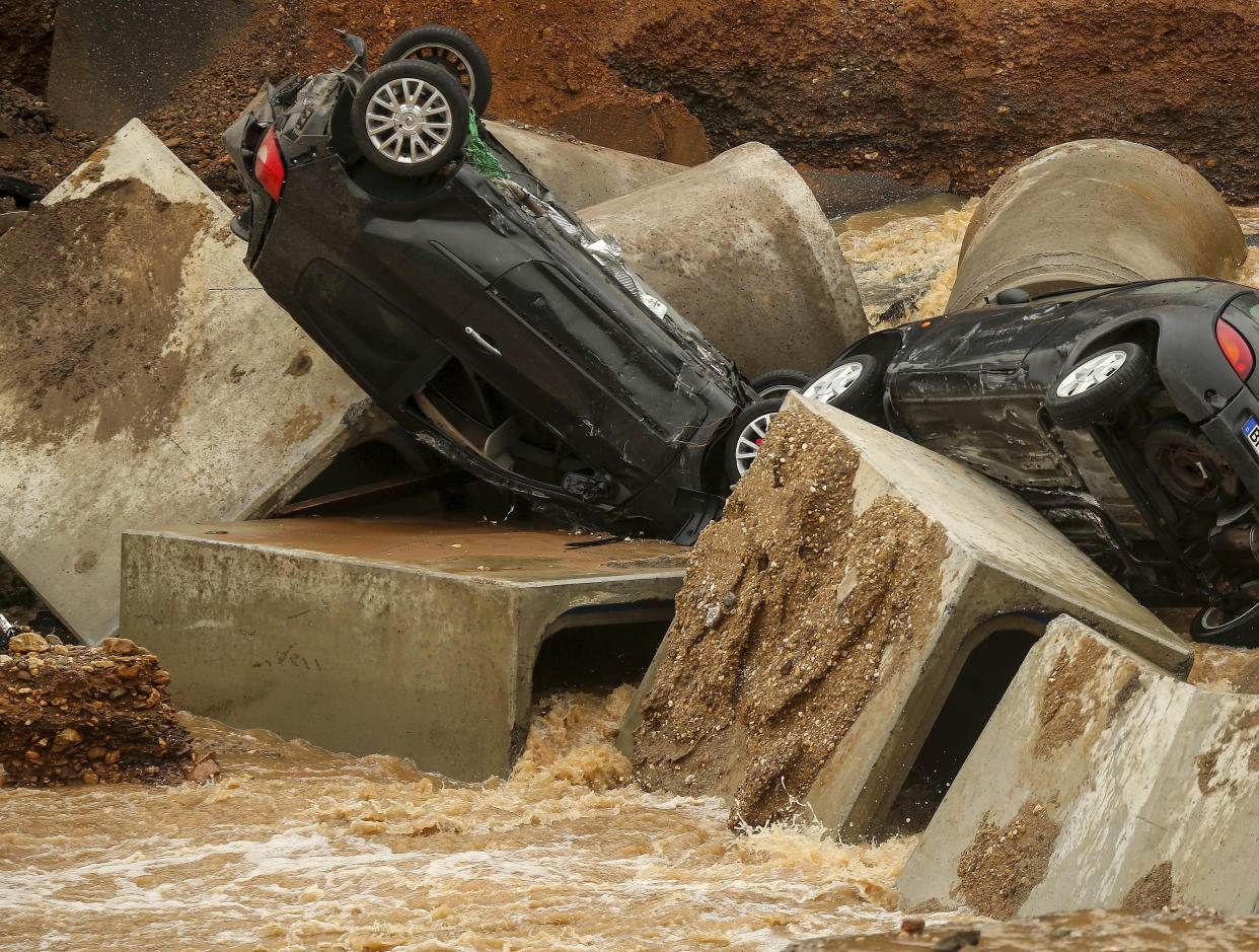 Cars lie in a washed out part of the Bessem district of Erftstadt, Germany, Friday, July 16, 2021. Heavy rains caused mudslides and flooding in the western part of Germany. Multiple have died and dozens are missing as severe flooding in Germany and Belgium turned streams and streets into raging, debris-filled torrents that swept away cars and toppled houses. (David Young/dpa via AP)