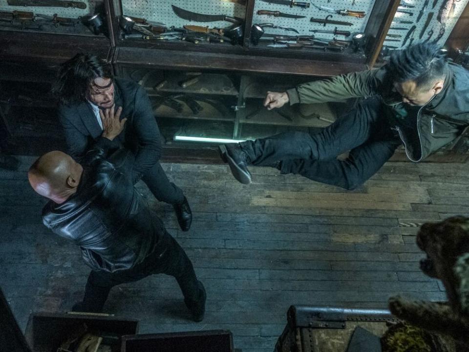 Keanu Reeves as John Wick fighting enemies surrounded by knives.