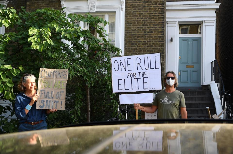 Demonstrators hold placards as they protest outside of the home of 10 Downing Street special advisor Dominic Cummings, in London on May 25, 2020 following his admission he drove and stayed in Durham during the coronavirus lockdown. - British Prime Minister Boris Johnson's top aide Dominic Cummings defied calls to resign on Monday over allegations that he broke coronavirus rules and undermined the government's response to the health crisis. Cummings told reporters that he acted "reasonably and legally" when he drove across the country with his wife while she was suffering from the virus, despite official advice to stay at home. (Photo by DANIEL LEAL-OLIVAS / AFP) (Photo by DANIEL LEAL-OLIVAS/AFP via Getty Images)