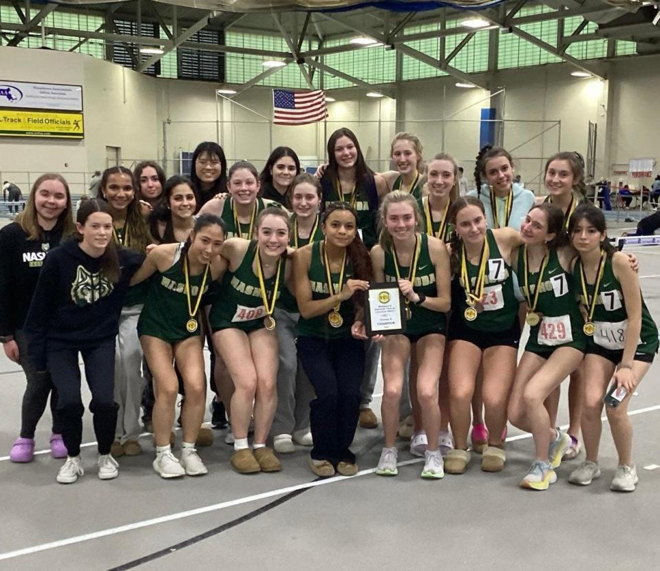 Members of the Nashoba girls' indoor track team celebrate their Mid-Wach B championship victory on Saturday at the Reggie Lewis Center.