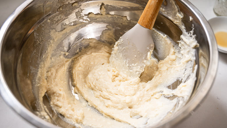 Rubber spatula mixing cream cheese filling in bowl