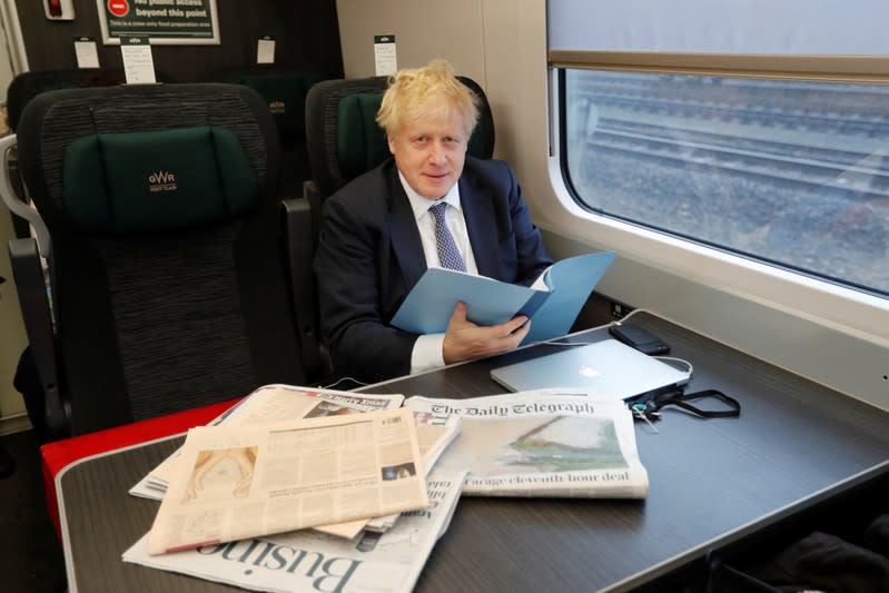 Britain's Prime Minister Boris Johnson looks up as he sits on a train, on his way to an election campaign event near Castle Cary