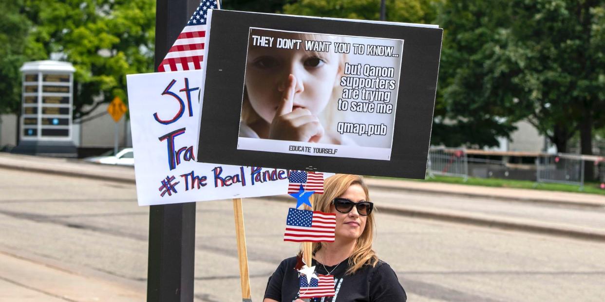 A woman in St. Paul, Minnesota, holds a sign at a Save our children rally. 