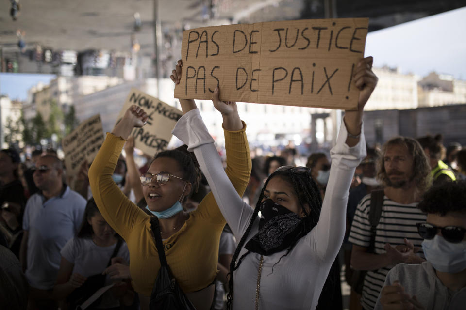 A protester chants while holding a sign that reads "No Justice No Peace" in Marseille, southern France, Saturday, June 6, 2020, to protest against the death of George Floyd. Floyd, a black man, died after he was restrained by police officers May 25 in Minneapolis, that has led to protests in many countries and across the U.S. Further protests are planned over the weekend in European cities, some defying restrictions imposed by authorities due to the coronavirus pandemic. (AP Photo/Daniel Cole)