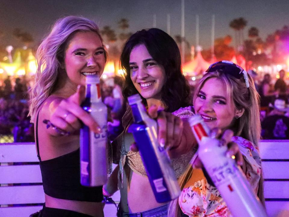 Alli Downey (from left), Jessica Arevalos and Erin McCurry pose for a photo together with their drinks during the Stagecoach country music festival in Indio, Calif., Friday, April 29, 2022.