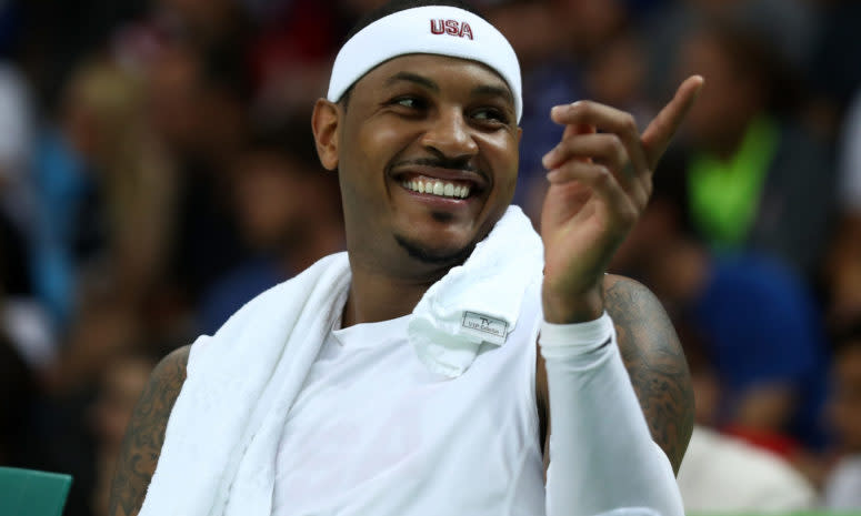 Carmelo Anthony smiling while on the bench for Team USA.