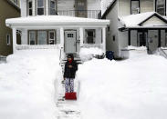 Raymond Santiago observes the snow in his neighborhood after shoveling snow by his front door in Buffalo, N.Y., on Tuesday, Dec. 27, 2022. Santiago, who's been in Buffalo for 35 years, says this is one of the worst snowstorms he's seen in the city. (Joseph Cooke/The Buffalo News via AP)