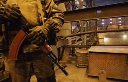 An armed man stands guard during the visit of head of the separatist self-proclaimed Donetsk People's Republic Alexander Zakharchenko (not pictured) to the Yuzovsky metallurgical plant in Donetsk, Ukraine, March 1, 2017. REUTERS/Alexander Ermochenko