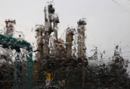 Chimneys of a factory are seen through rain drops on a car window in the rain at the Keihin industrial zone in Kawasaki, south of Tokyo, Japan, August 18, 2016. Picture taken August 18, 2016. REUTERS/Kim Kyung-Hoon